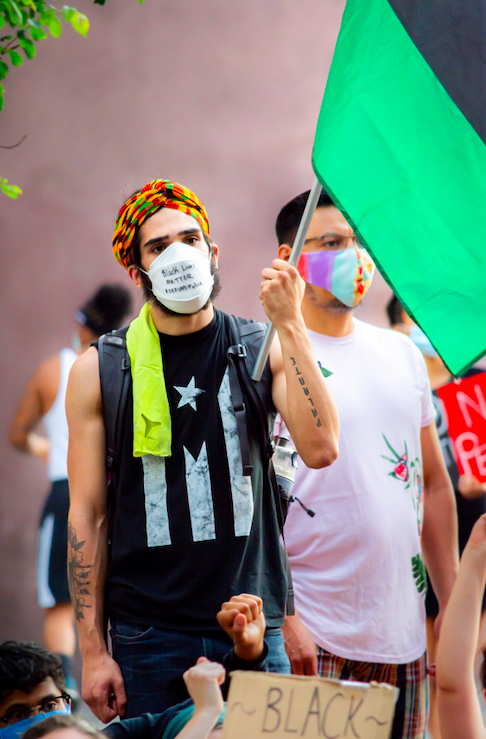 juneteenth clockingyou man holding flag at protest black lives matter gayatri-malhotra unsplash